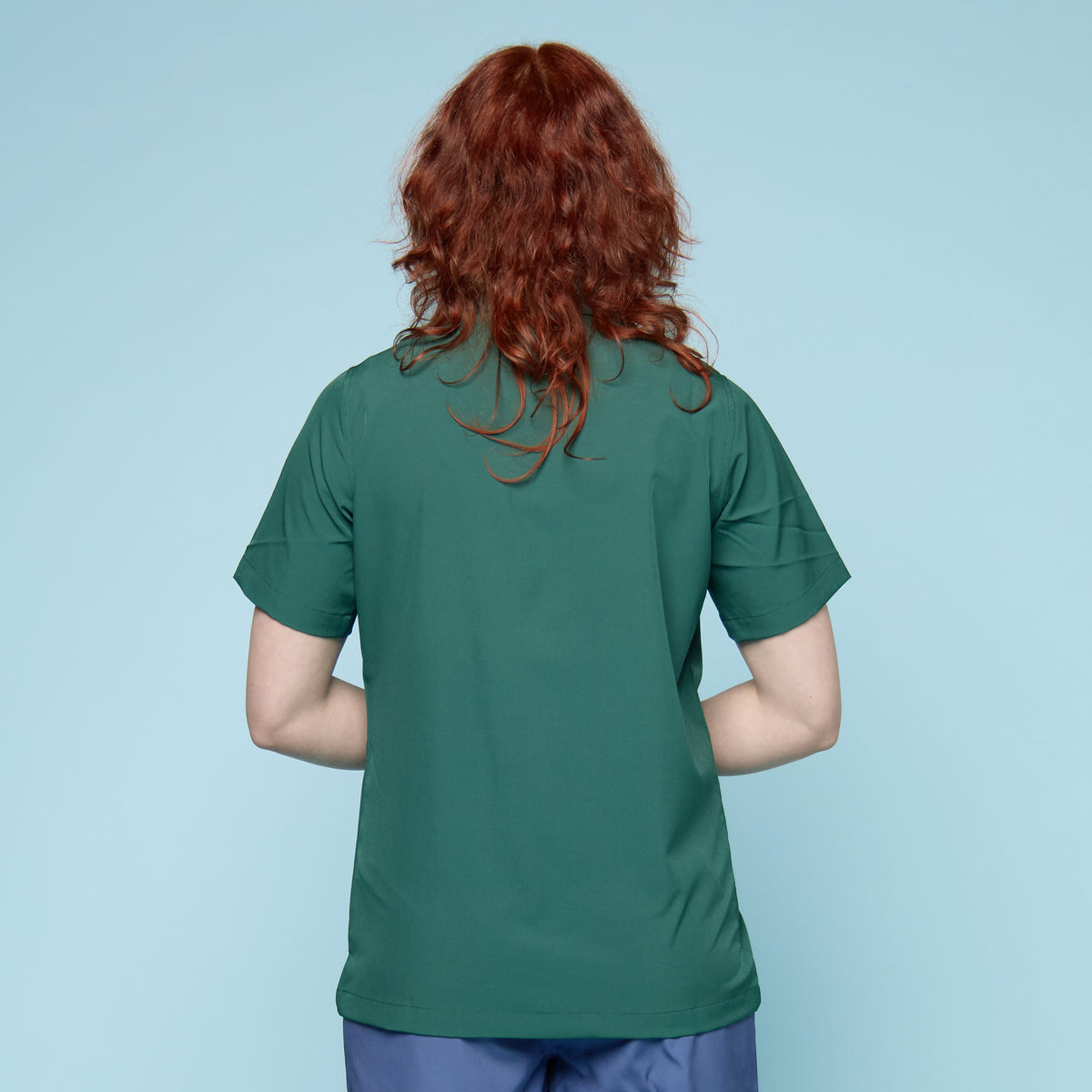 Rear view of moss green gender-affirming swim shirt showing relaxed cut and longer length