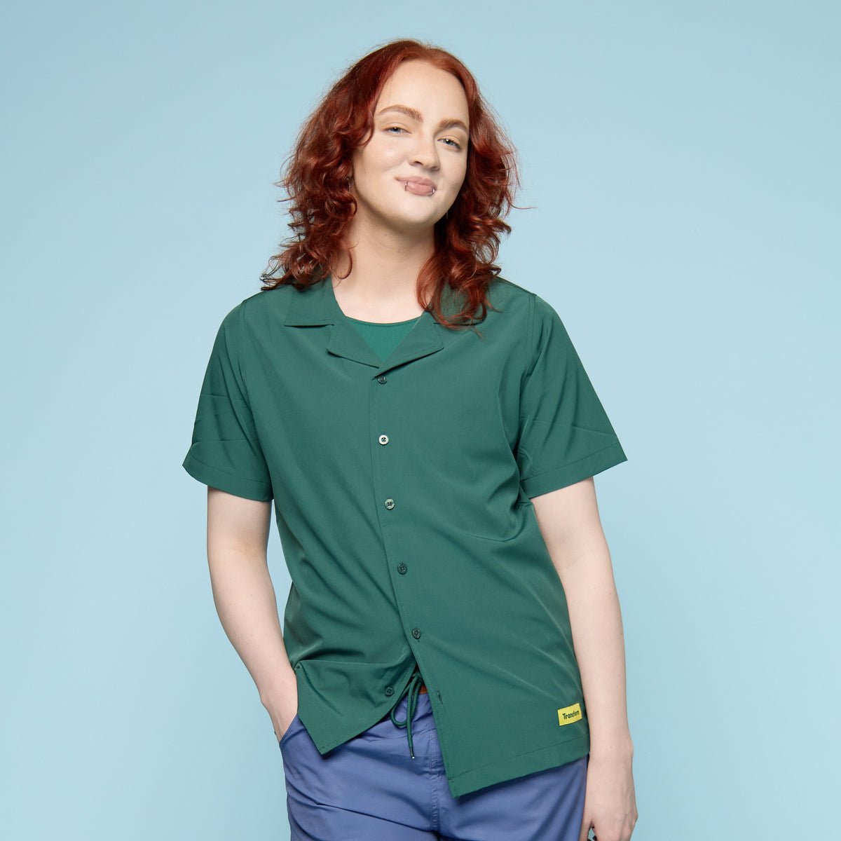 Gender-affirming swim shirt in moss green with button-up collar, front view, worn by trans masc model