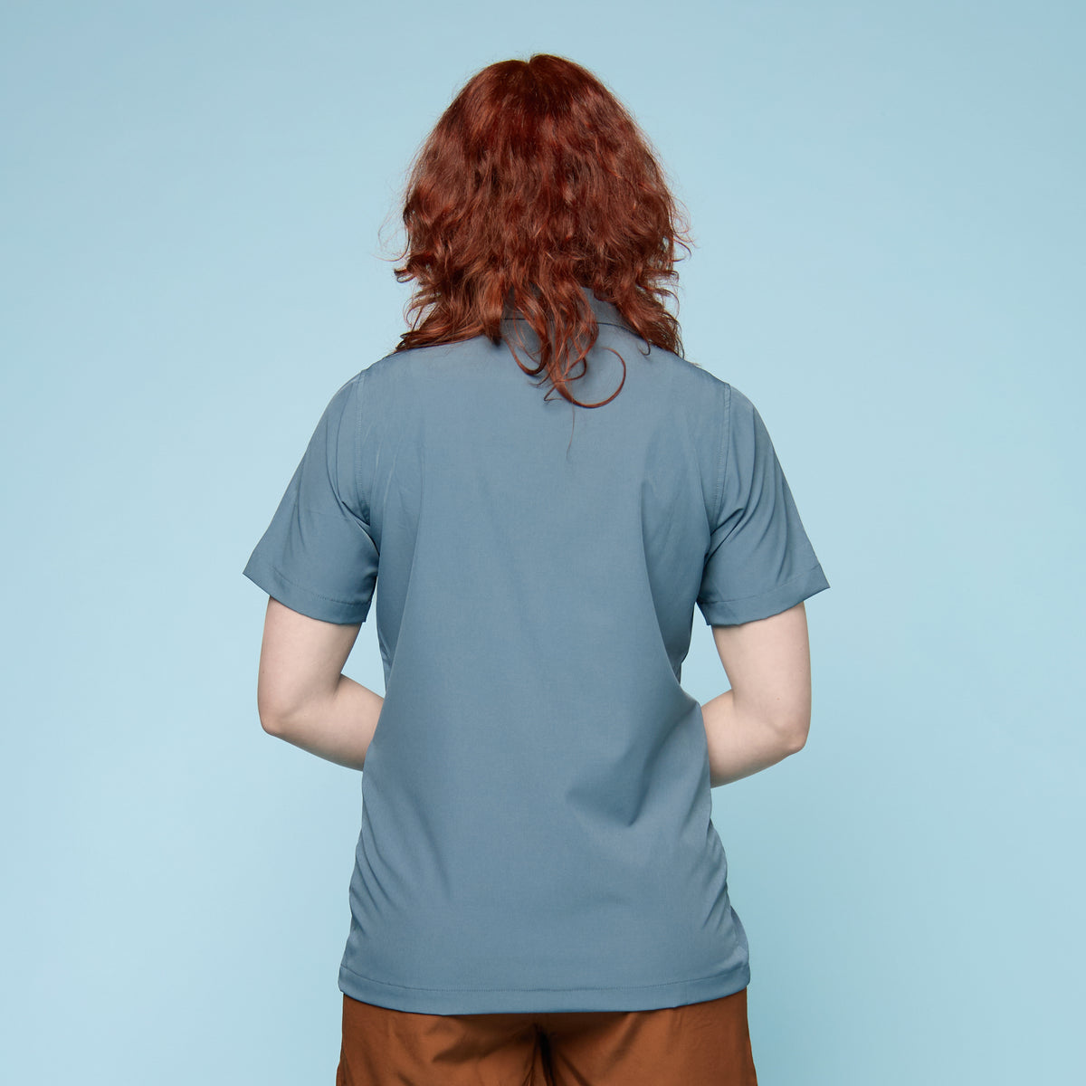 Rear view of steel blue gender-affirming swim shirt showing relaxed fit and longer length